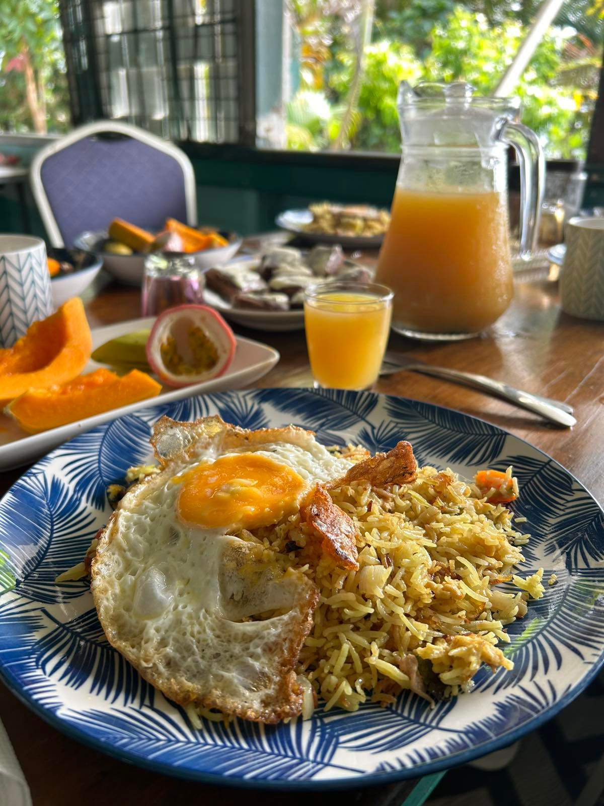 Tropical breakfast with fried rice, egg, fresh juice and papaya